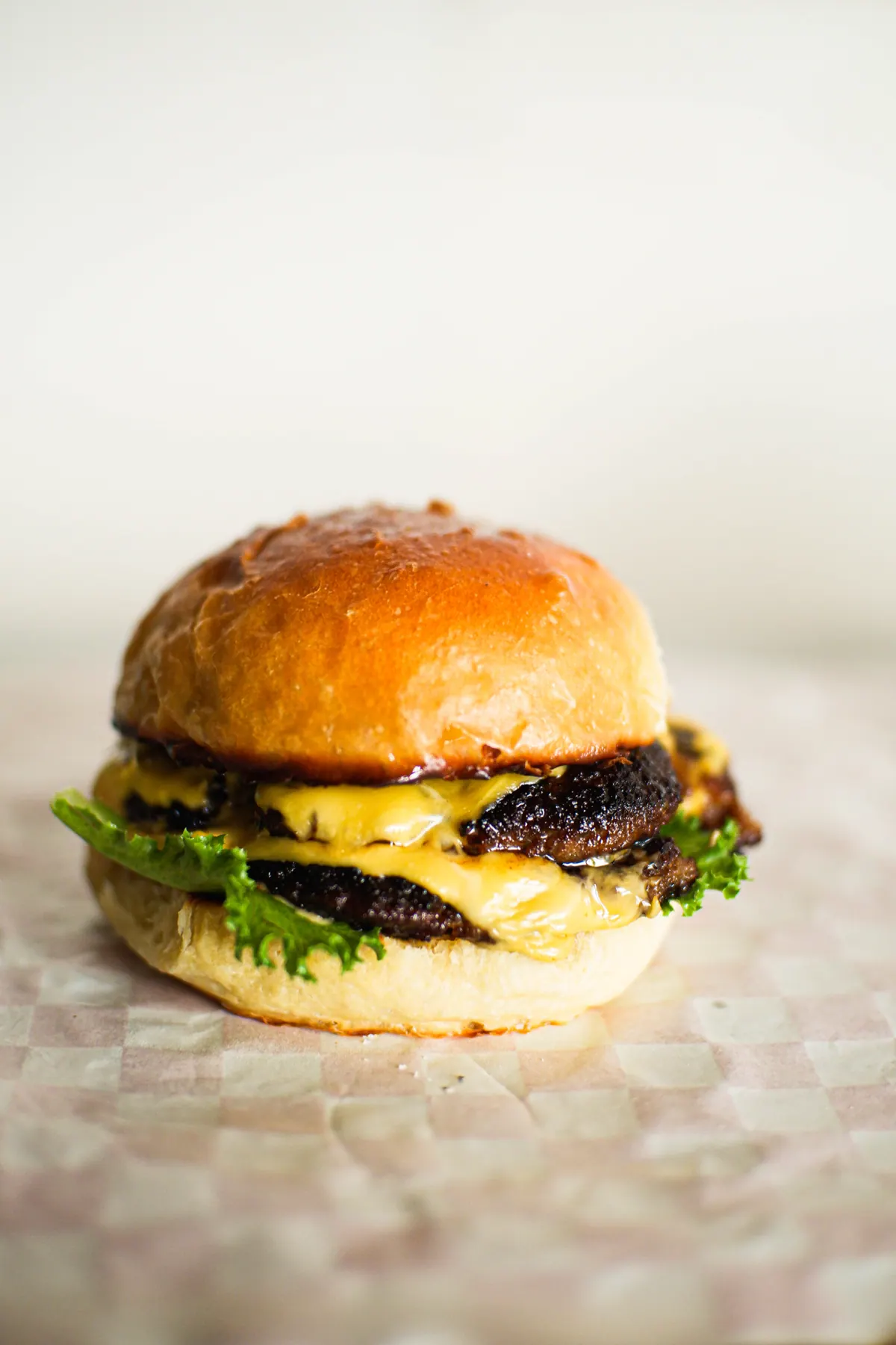 A Byrdhouse burger with melted cheese and lettuce on a brioche bun