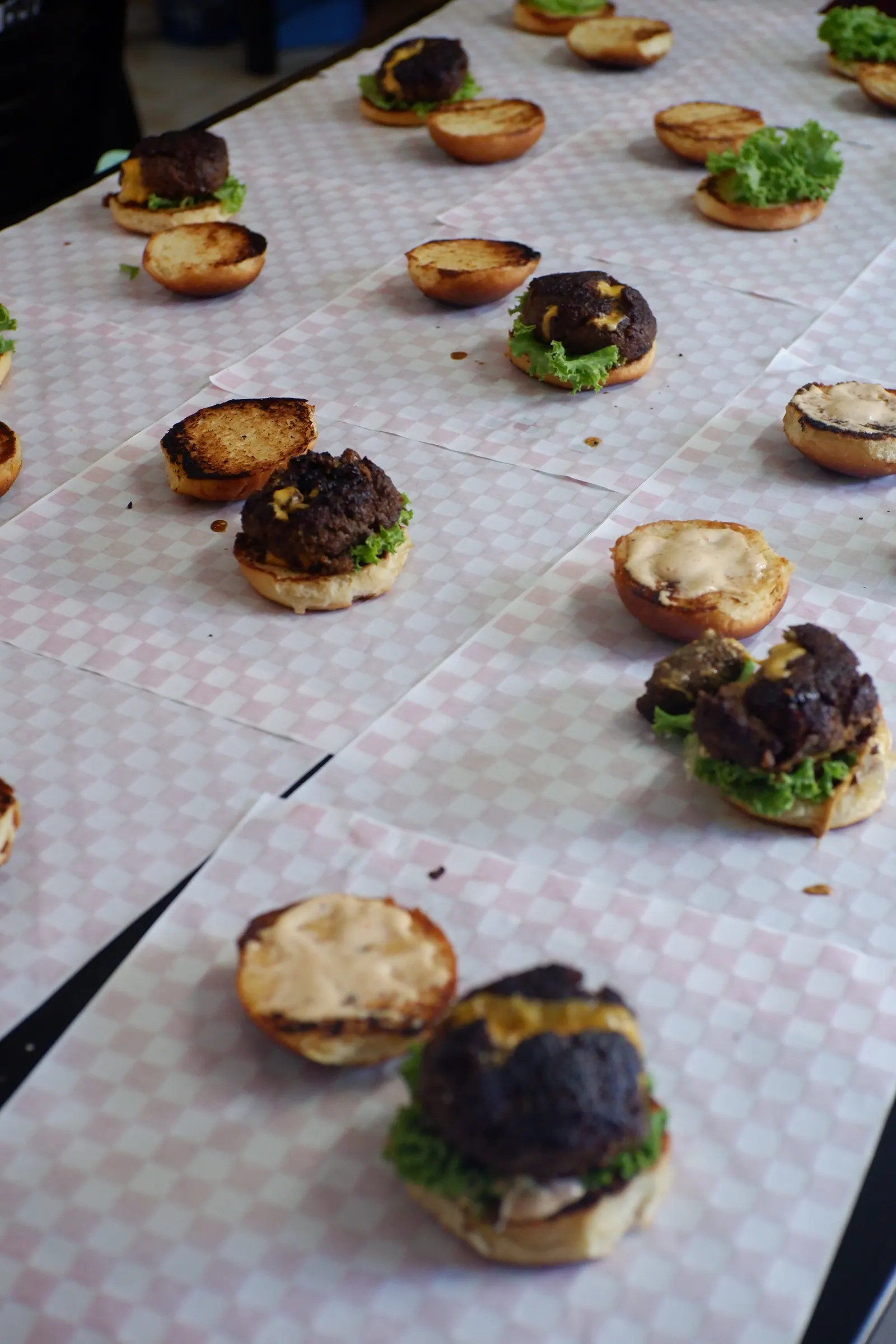 Dozens of open-faced sliders laid out in rows on checked paper