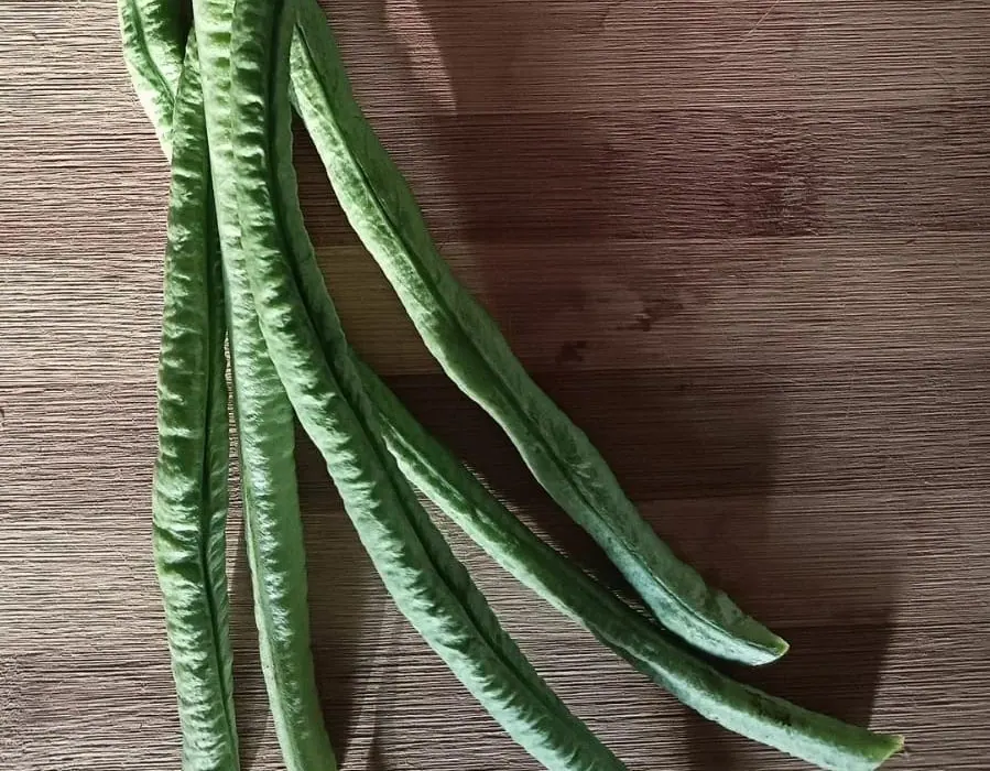 Long beans on a wooden board, ready to be cut