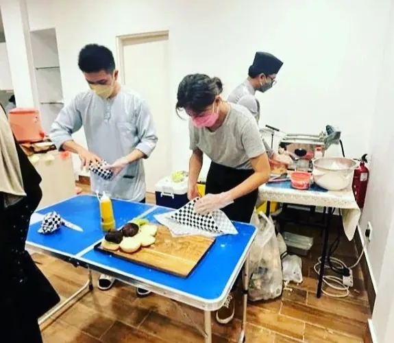 Burgers being prepped on a folding table at a catering job